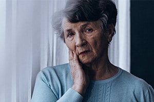 Sad older woman experiencing nursing home abuse